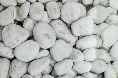 What to put under rocks to prevent weeds?